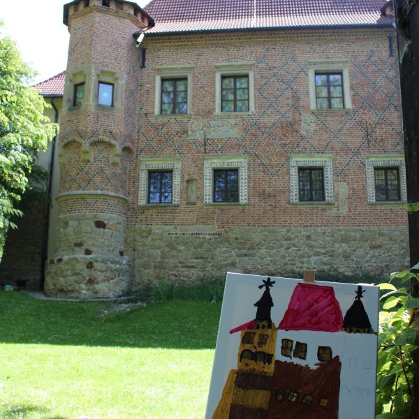 ceglany zamek na tle zielonych drzew