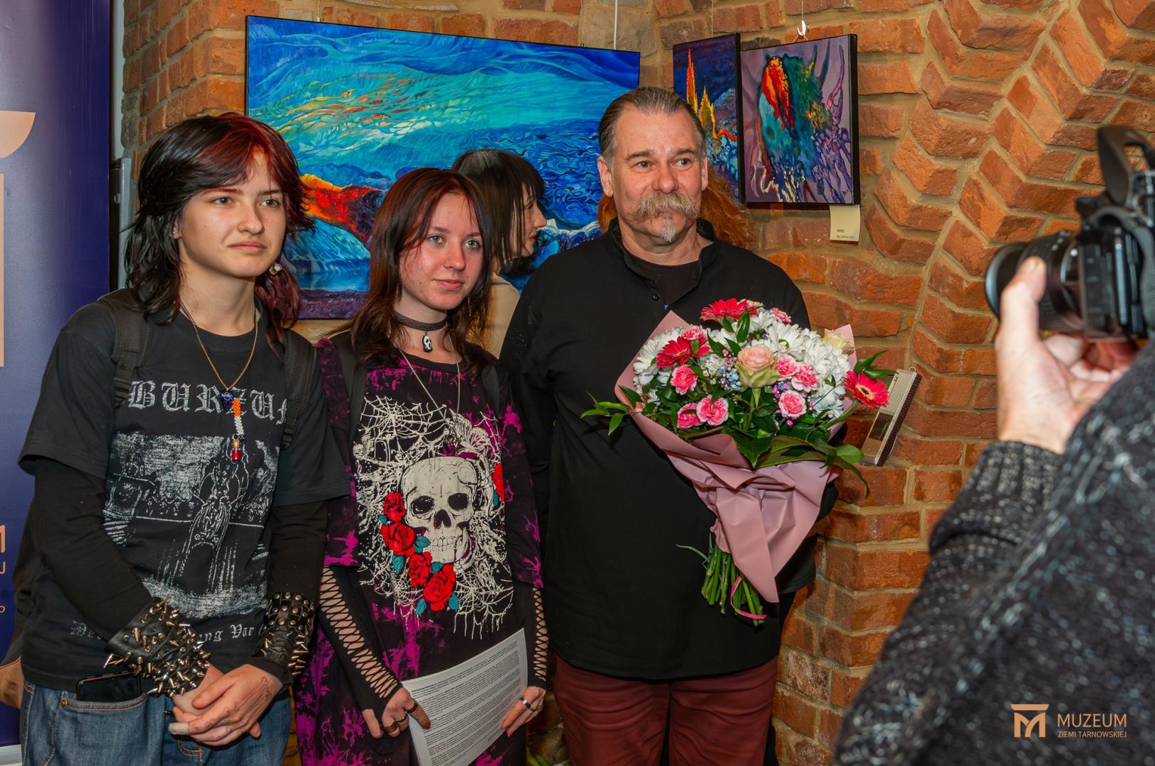 Uczestnicy wernisażu robią sobie zdjęcie z Michałem Porębą